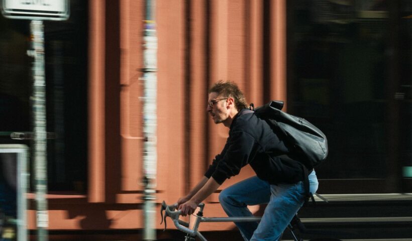 Fiatal férfi biciklizik a városi forgalomban